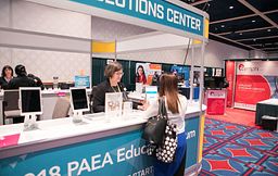 A PAEA staff member interacts with a Forum attendee.